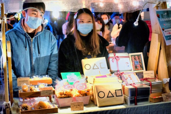 Когда мир окончательно «окальмарился». Печенье с символикой сериала на рождественской ярмарке на Тайване | <a href="https://api.vc.ru/v2.8/redirect?to=https%3A%2F%2Fwww.google.com%2Furl%3Fq%3Dhttps%3A%2F%2Fcommons.wikimedia.org%2Fwiki%2FFile%3ASquid_Game_Cookie_Street_Vendor.jpg%26amp%3Bsa%3DD%26amp%3Bsource%3Ddocs%26amp%3Bust%3D1744802530631468%26amp%3Busg%3DAOvVaw0-T6v2AJoea5iRtVwHcqom&postId=1844103" rel="nofollow noreferrer noopener" target="_blank">Источник</a>