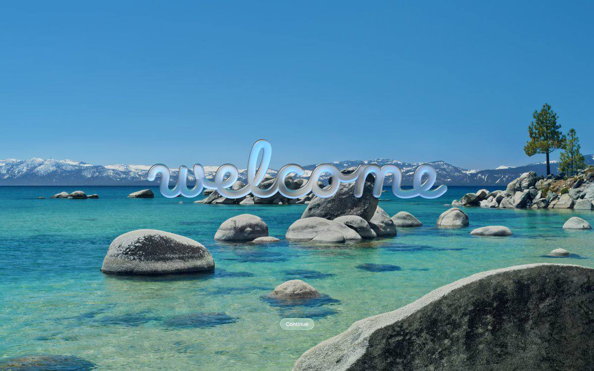 Новый экран с обоями «Tahoe Day» приветствия с надписью «Welcome» (на языке системы) в стиле «Liquid Glass»