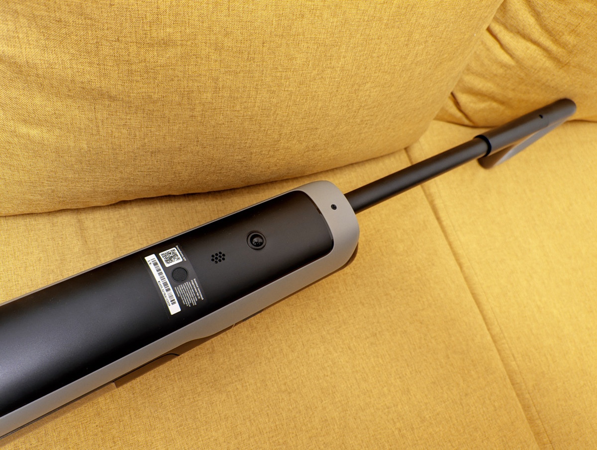 Dreame H15S: тыльная сторона корпуса, на которую вынесена решетка динамика для голосовых подсказок, колесико для горизонтального перемещения пылесоса, отверстие для демонтажа рукояти, а также QR-код для скачивания мобильного приложение Dreamehome