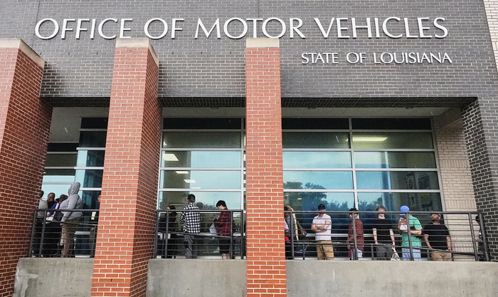 Как менеджеры становятся причиной ИТ-катастроф - 6 A line of people wait outside a building which says Office of Motor Vehicles State of Louisiana.