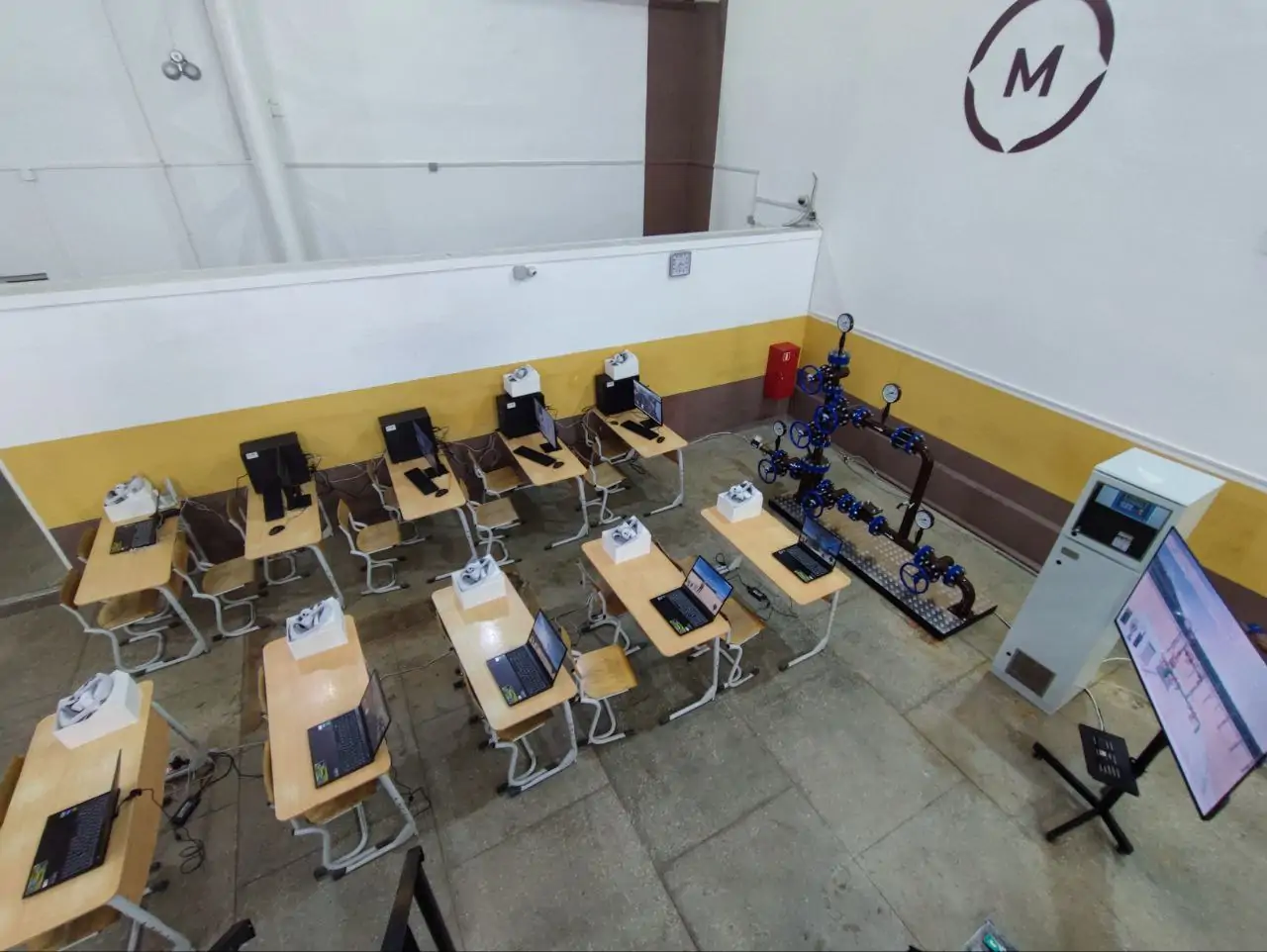 Внешний вид тренажера по обучению операторов добычи (УЭЦН) - интерактивный макет фонтанной арматуры, интерактивный макет станции управления (сенсорный экран), система отображения - телевизор, шлемы VR, ноутбуки. (https://lcontent.ru/product/kustovaya-ploshhadka/)