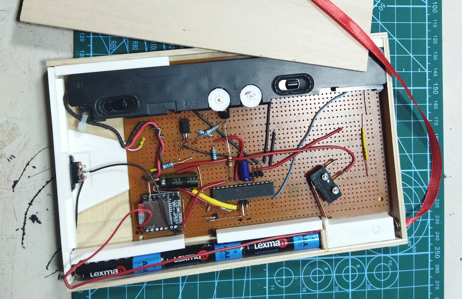 Финал работ с нутром корпуса; видно первый вариант плюсового контакта — длинный красный провод, припаянный к куску никелевой ленты. Он оказался неудачным — очень малая жёсткость, неудобно вставлять. Был заменен на просто кусок никелевой ленты, изогнутой по радиусу батареек и подпаянный буквой Г на конце. Получилось жёстко и удобно