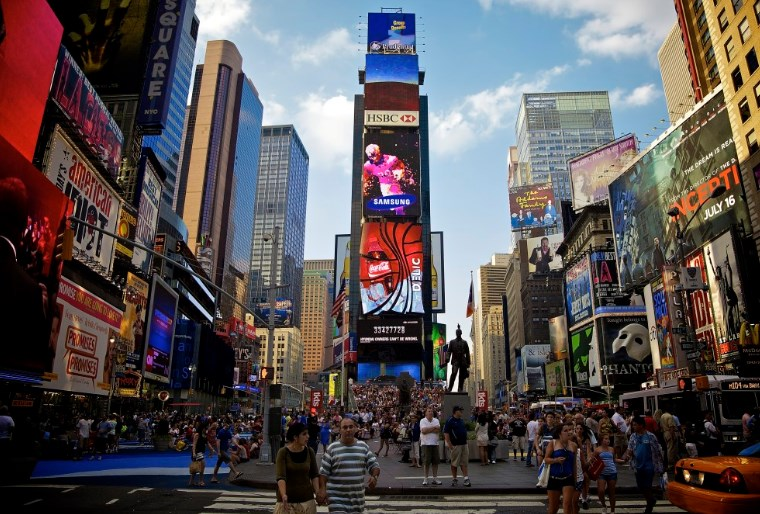 Фото Таймс-сквера в Нью-Йорке с большим количеством людей, рекламных баннеров и зданий.