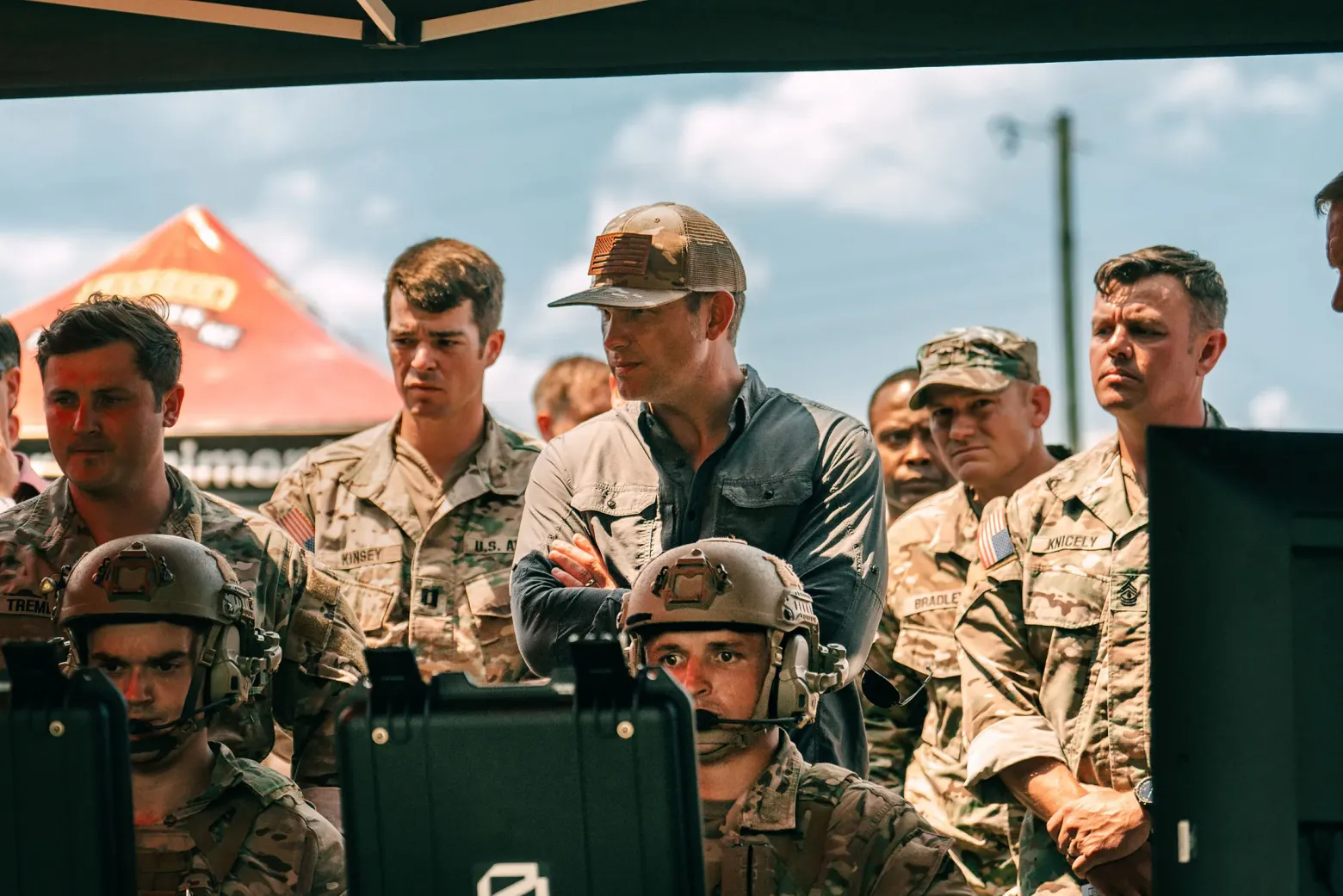 Пит Хегсет со скрещенными руками в окружении военных