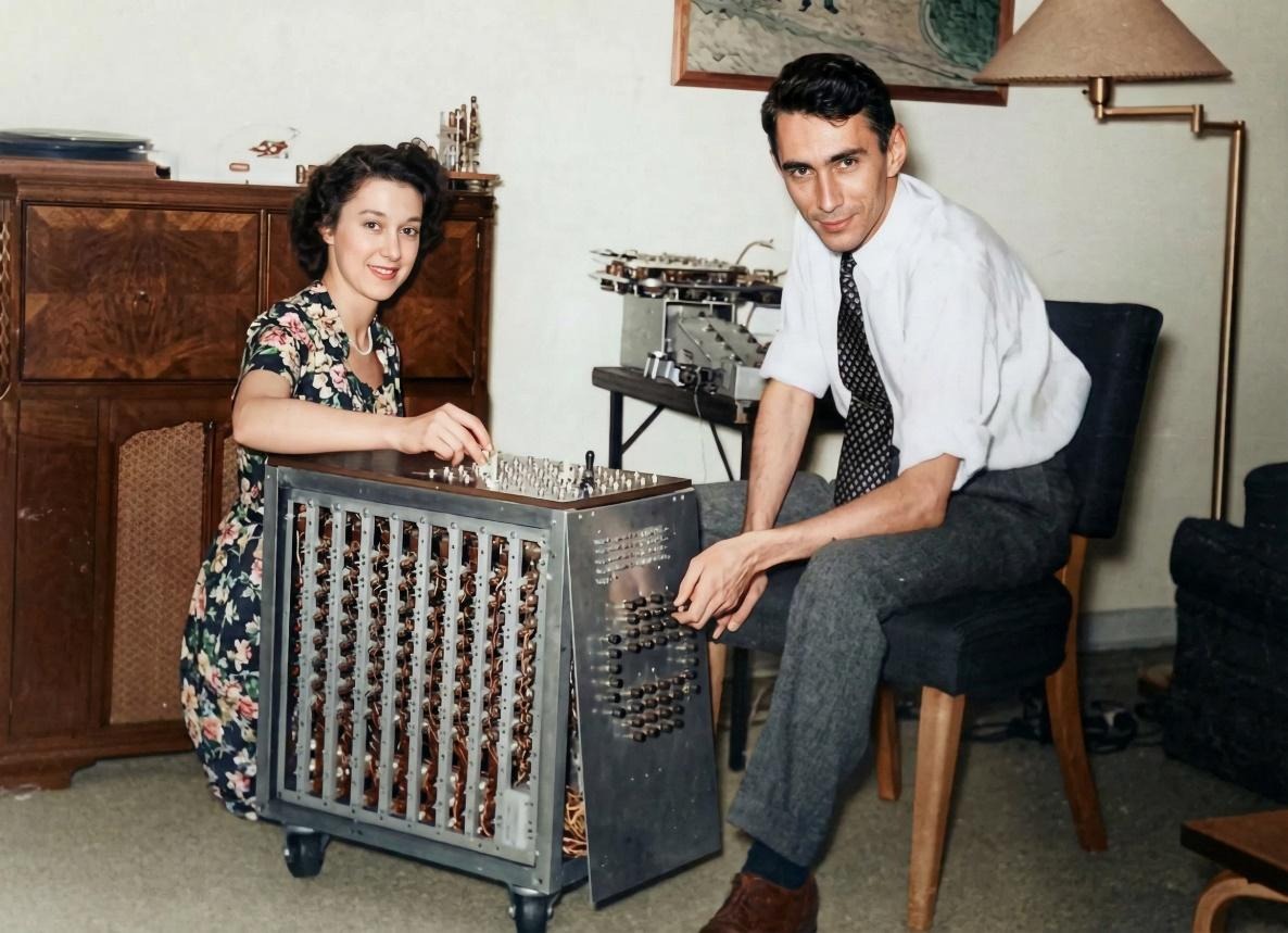 Клод и Бетти Шеннон у себя дома с одной из версий шахматной машины. Скорее всего — это первый шахматный компьютер, Шеннона, который умел играть только эндшпили.  Оригинальное изображение, раскрашено в нейросети