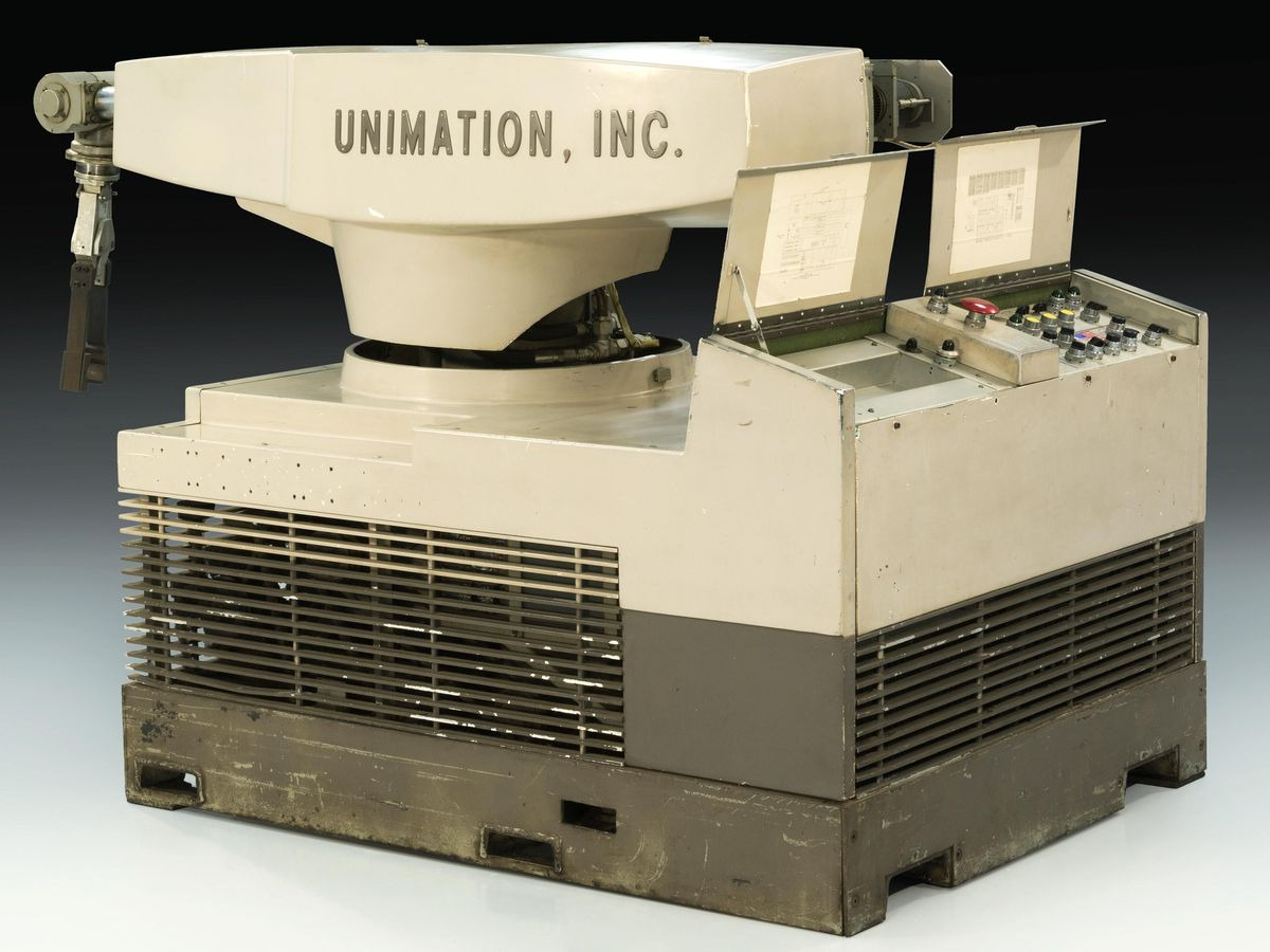 Вот каким парнем он был! Источник: IEEE. A robot arm sitting on a rectangular base with control panels at the back.